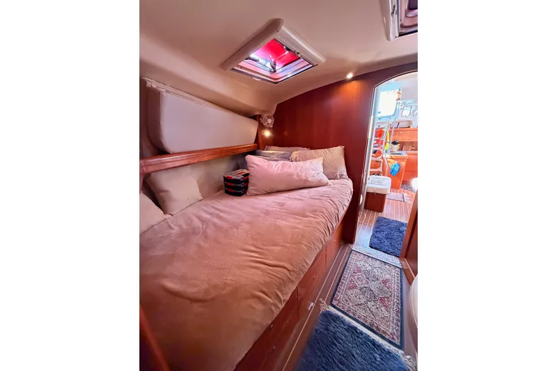 Thursday's Child Yacht Photos Pics Cozy cabin interior of 2005 Hunter Passage 456 yacht with plush bedding and warm lighting.
