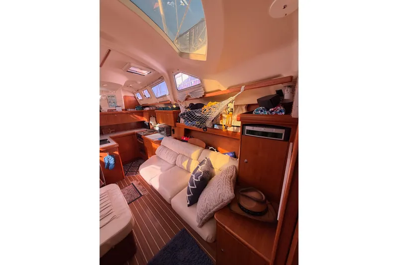 Thursday's Child Yacht Photos Pics Interior of 2005 Hunter Passage 456 yacht with cozy seating and wooden cabinetry.