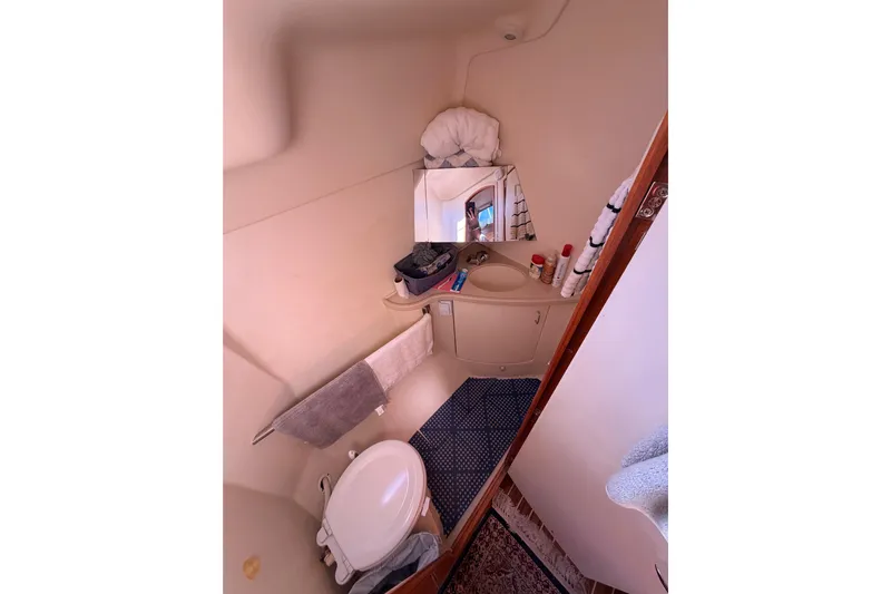 Thursday's Child Yacht Photos Pics Compact bathroom in 2005 Hunter Passage 456 yacht with sink, mirror, and toilet.