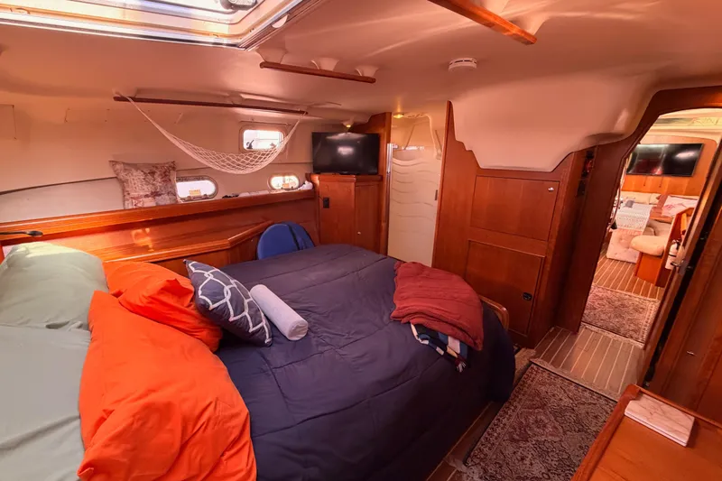 Thursday's Child Yacht Photos Pics Luxurious 2005 Hunter Passage 456 yacht interior with cozy bedroom and elegant wood finishes.