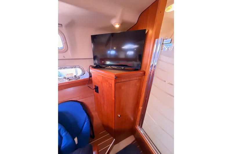 Thursday's Child Yacht Photos Pics Interior of 2005 Hunter Passage 456 yacht with TV and wooden cabinetry.