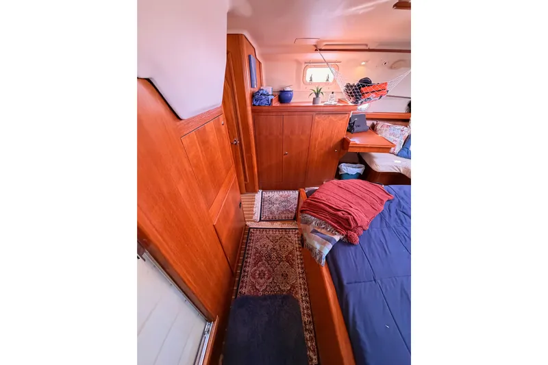 Thursday's Child Yacht Photos Pics Interior of 2005 Hunter Passage 456 yacht with wooden cabinetry and cozy bedding.