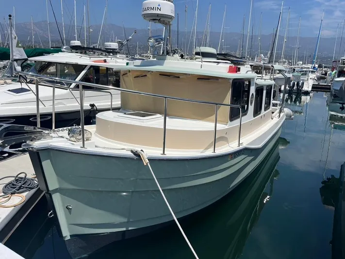 Ben Yacht Photos Pics 2011 Ranger Tugs R-27 boat docked in a marina, surrounded by other vessels.