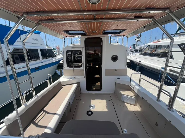 Ben Yacht Photos Pics 2011 Ranger Tugs R-27 boat interior with seating and docked yachts in background.