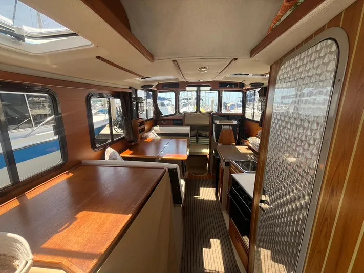 Ben Yacht Photos Pics Interior of 2011 Ranger Tugs R-27 boat, featuring wood finishes and ample natural light.
