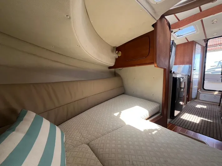 Ben Yacht Photos Pics Interior of 2011 Ranger Tugs R-27 boat with cozy sleeping area and wooden accents.