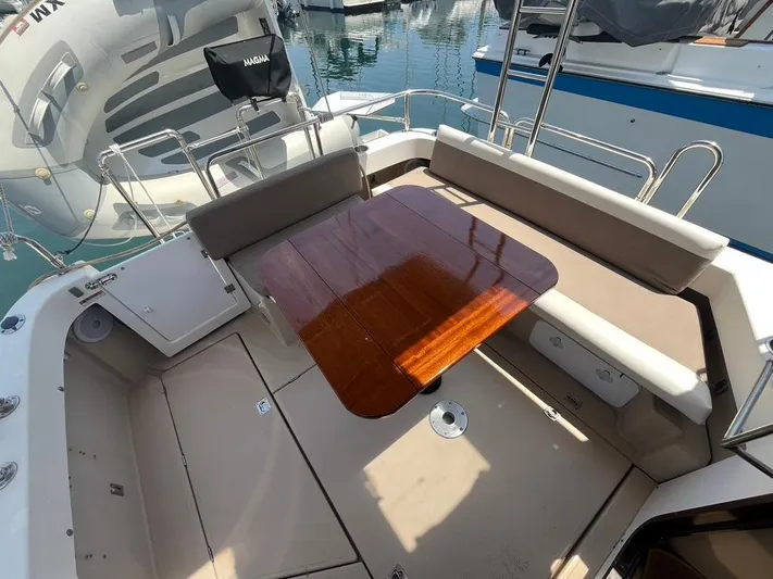Ben Yacht Photos Pics 2011 Ranger Tugs R-27 boat cockpit with wooden table and cushioned seating.