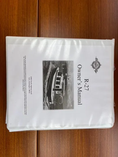 Ben Yacht Photos Pics Owner's manual for 2011 Ranger Tugs R-27 boat on wooden table.