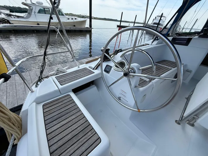 Corrine Yacht Photos Pics Cockpit of 2015 Jeanneau 409 sailboat with steering wheel and seating, docked at marina.