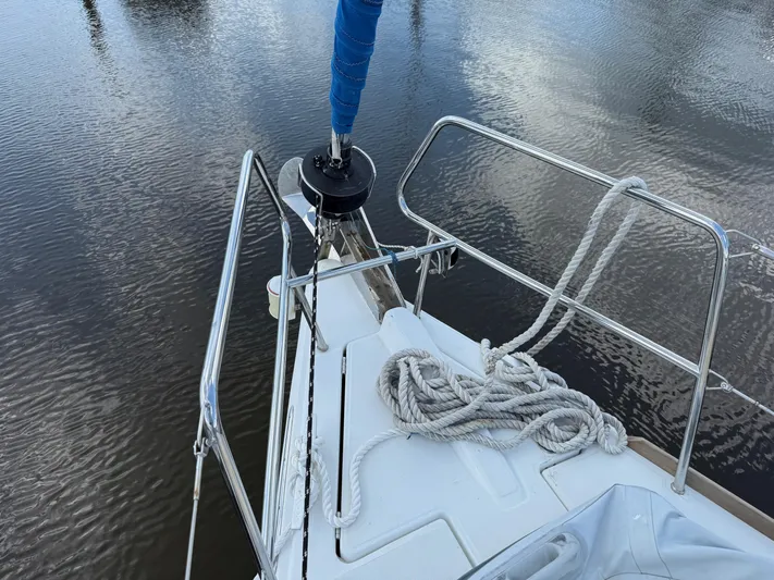 Corrine Yacht Photos Pics Bow of 2015 Jeanneau 409 sailboat with coiled rope and calm water.