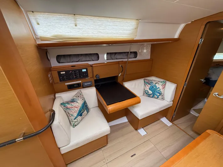 Corrine Yacht Photos Pics Interior of 2015 Jeanneau 409 sailboat with cozy seating and nautical-themed cushions.
