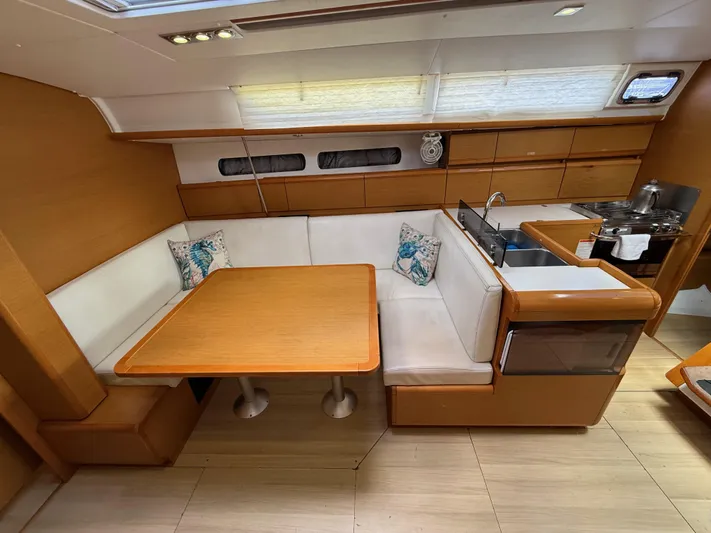 Corrine Yacht Photos Pics Interior of 2015 Jeanneau 409 yacht with wooden dining area and compact kitchen.