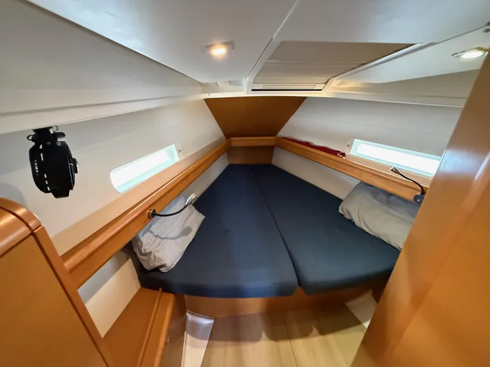 Corrine Yacht Photos Pics Cozy cabin interior of 2015 Jeanneau 409 sailboat with blue cushions and wooden finish.