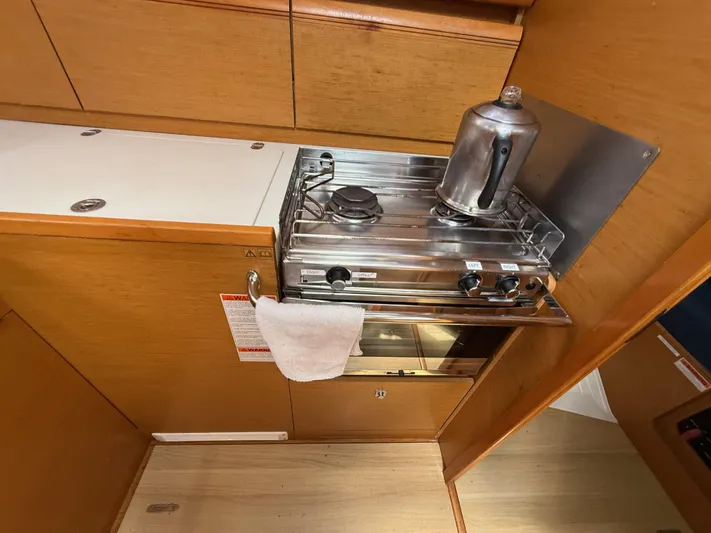 Corrine Yacht Photos Pics Compact kitchen area in a 2015 Jeanneau 409 sailboat with stove and kettle.