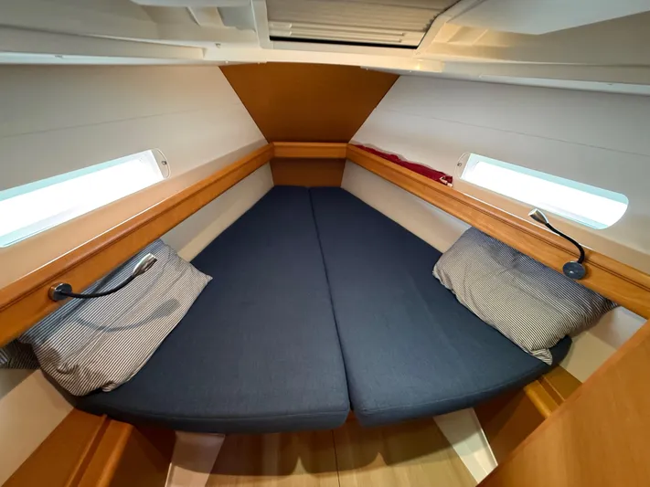 Corrine Yacht Photos Pics Cozy cabin interior of 2015 Jeanneau 409 sailboat with blue cushions and striped pillows.