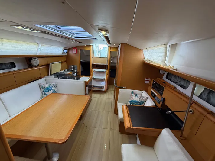 Corrine Yacht Photos Pics Interior of 2015 Jeanneau 409 sailboat with modern wood finish and seating area.
