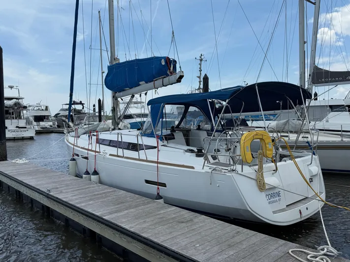 Corrine Yacht Photos Pics 2015 Jeanneau 409 sailboat docked at marina, featuring blue canopy and white hull.
