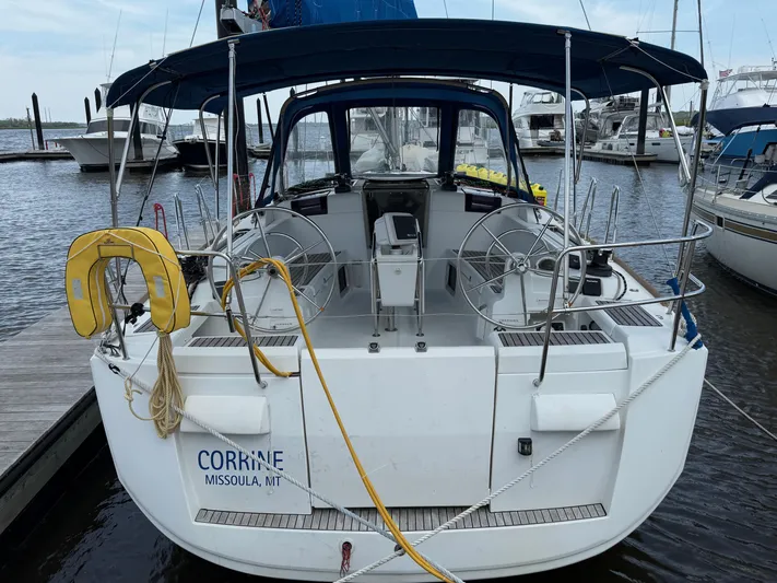 Corrine Yacht Photos Pics 2015 Jeanneau 409 sailboat docked, featuring dual steering wheels and a blue canopy.