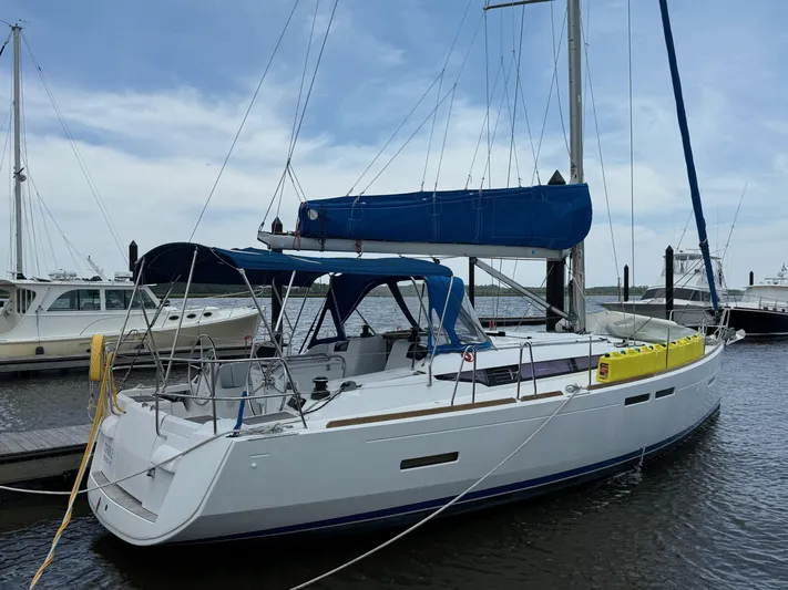 Corrine Yacht Photos Pics 2015 Jeanneau 409 sailboat docked at marina, featuring blue sail cover and canopy.