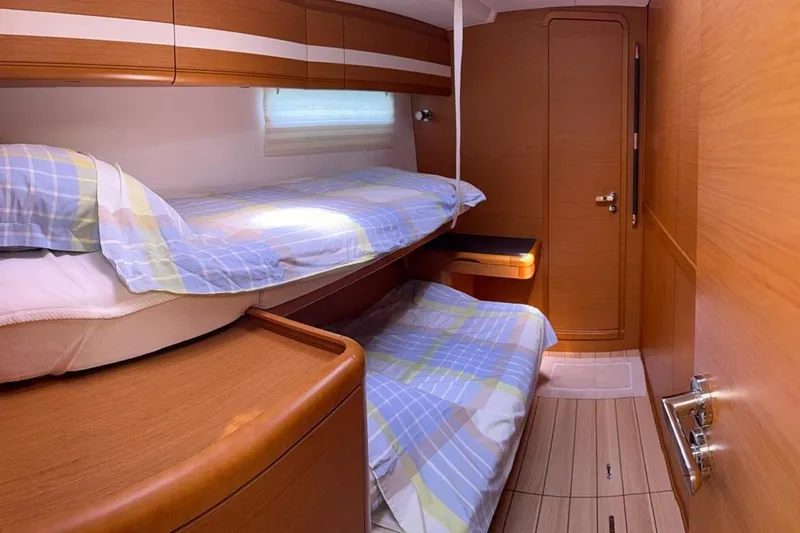 Bobbi Dazzler Yacht Photos Pics Cozy cabin interior of 2013 Jeanneau 57 yacht with bunk beds and wooden finish.