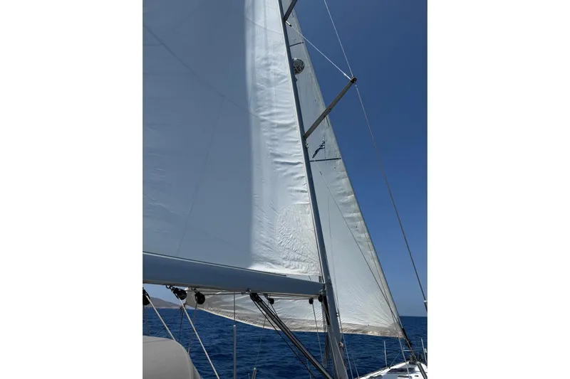 Bobbi Dazzler Yacht Photos Pics Sailing on a 2013 Jeanneau 57 yacht with white sails against a clear blue sky.