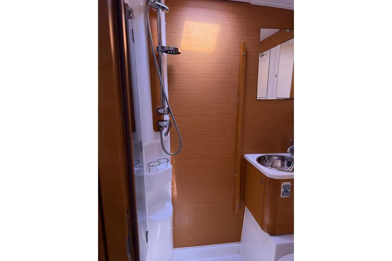 Bobbi Dazzler Yacht Photos Pics 2013 Jeanneau 57 yacht bathroom with shower, sink, and wooden paneling.