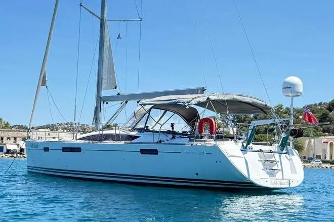 Bobbi Dazzler Yacht Photos Pics 2013 Jeanneau 57 sailboat anchored in clear blue water, featuring sleek design and spacious deck.