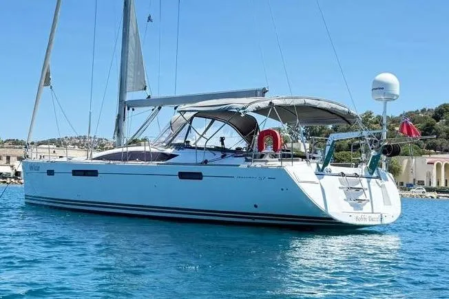 Bobbi Dazzler Yacht Photos Pics 2013 Jeanneau 57 sailboat anchored in clear blue water, featuring sleek design and modern amenities.