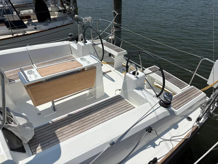Aveyron Yacht Photos Pics 2021 Beneteau Oceanis 35.1 sailboat cockpit with dual steering wheels and wooden seating.