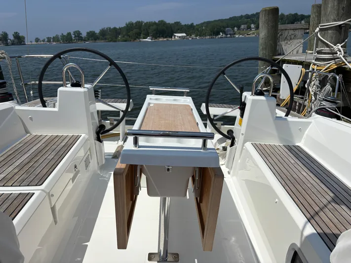 Aveyron Yacht Photos Pics 2021 Beneteau Oceanis 35.1 sailboat cockpit with dual steering wheels and wooden seating.