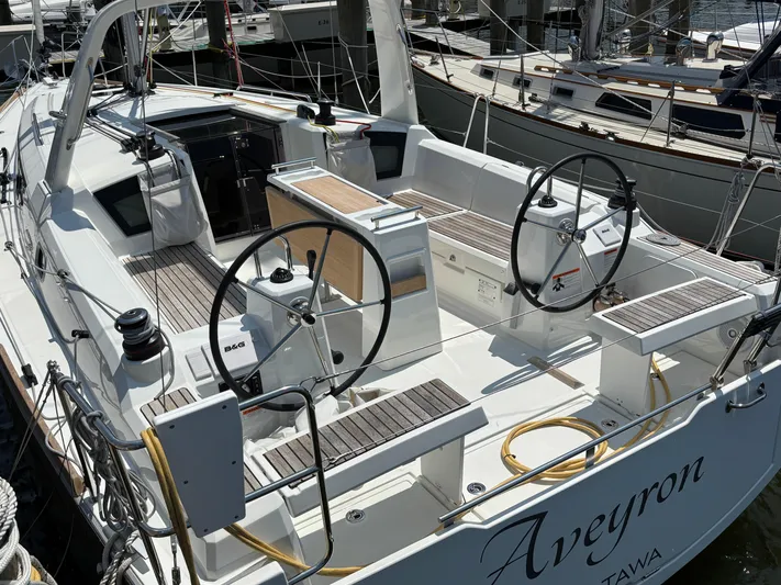Aveyron Yacht Photos Pics 2021 Beneteau Oceanis 35.1 sailboat cockpit with dual steering wheels and teak seating.