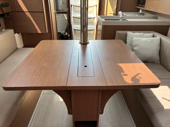 Aveyron Yacht Photos Pics Interior of 2021 Beneteau Oceanis 35.1 yacht with wooden dining table and seating.