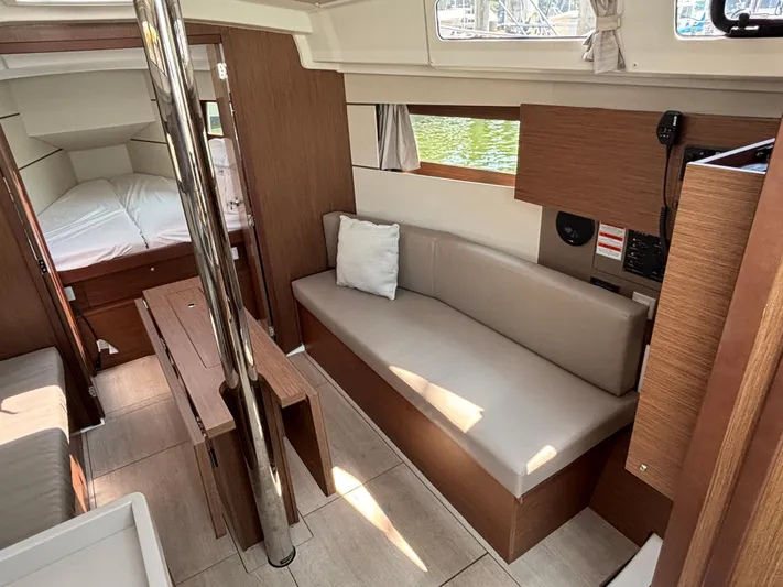 Aveyron Yacht Photos Pics Interior of 2021 Beneteau Oceanis 35.1 yacht, featuring cozy seating and modern wood finishes.
