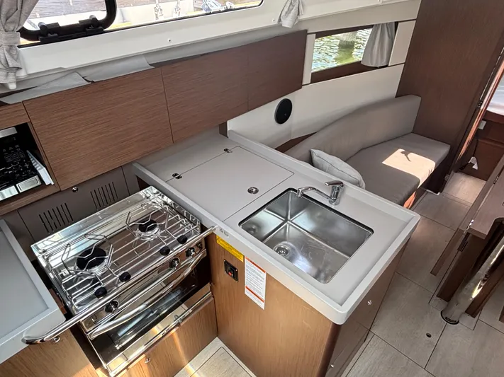 Aveyron Yacht Photos Pics Modern kitchen interior of 2021 Beneteau Oceanis 35.1 yacht with stove and sink.