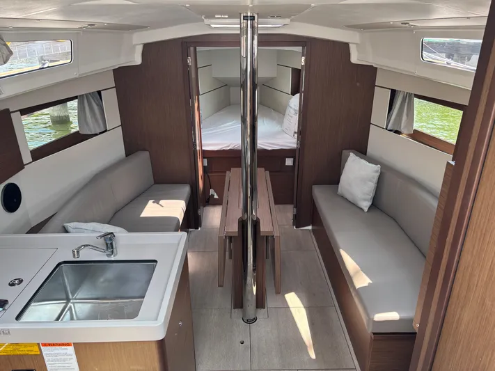 Aveyron Yacht Photos Pics Interior of 2021 Beneteau Oceanis 35.1 yacht, featuring modern seating and compact kitchen area.