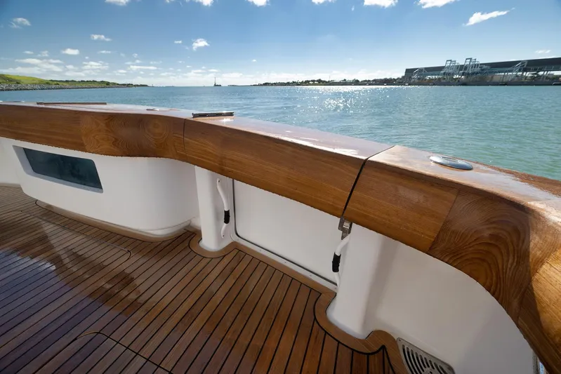 Even Flow Yacht Photos Pics 2009 Viking Convertible yacht deck with polished wood finish, overlooking serene waters.