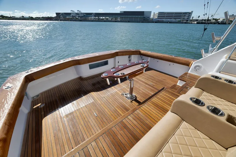 Even Flow Yacht Photos Pics 2009 Viking Convertible yacht deck with wooden flooring and seating, overlooking calm waters.