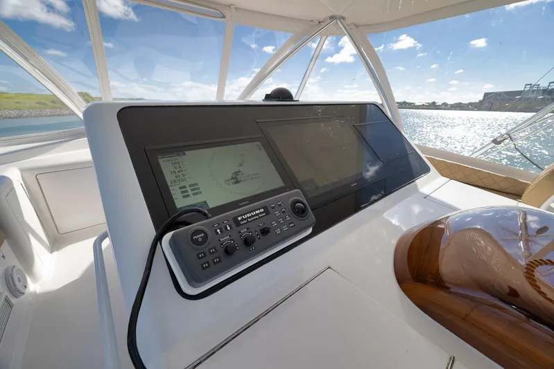 Even Flow Yacht Photos Pics 2009 Viking Convertible yacht helm with navigation system, overlooking sunny waters.