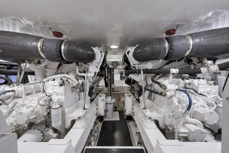 Even Flow Yacht Photos Pics Engine room of a 2009 Viking Convertible yacht, showcasing dual engines and complex piping.