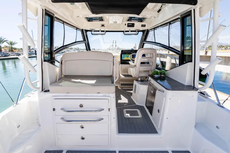 A Day In The Life Yacht Photos Pics 2021 Boston Whaler 325 Conquest interior with helm, seating, and cabinetry.
