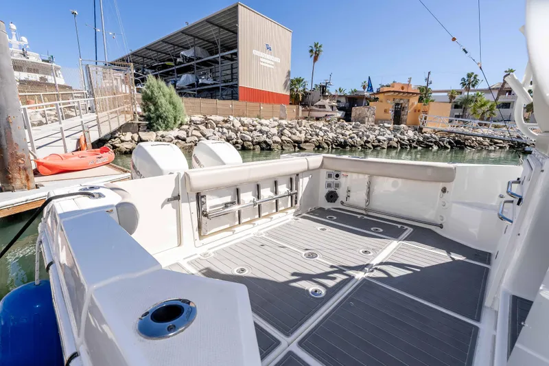 A Day In The Life Yacht Photos Pics 2021 Boston Whaler 325 Conquest boat docked at marina, showcasing spacious deck area.