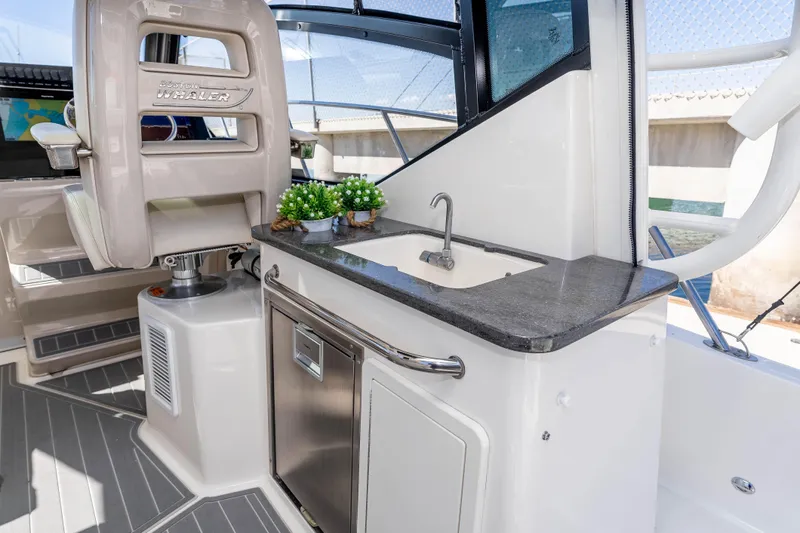 A Day In The Life Yacht Photos Pics 2021 Boston Whaler 325 Conquest interior with sink, counter, and captain's chair.