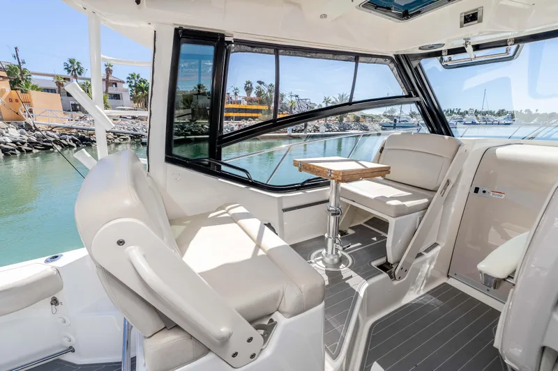 A Day In The Life Yacht Photos Pics Interior of 2021 Boston Whaler 325 Conquest boat with seating and table, dockside view.