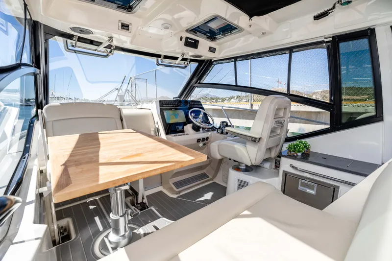 A Day In The Life Yacht Photos Pics Interior of 2021 Boston Whaler 325 Conquest boat with helm, seating, and table.