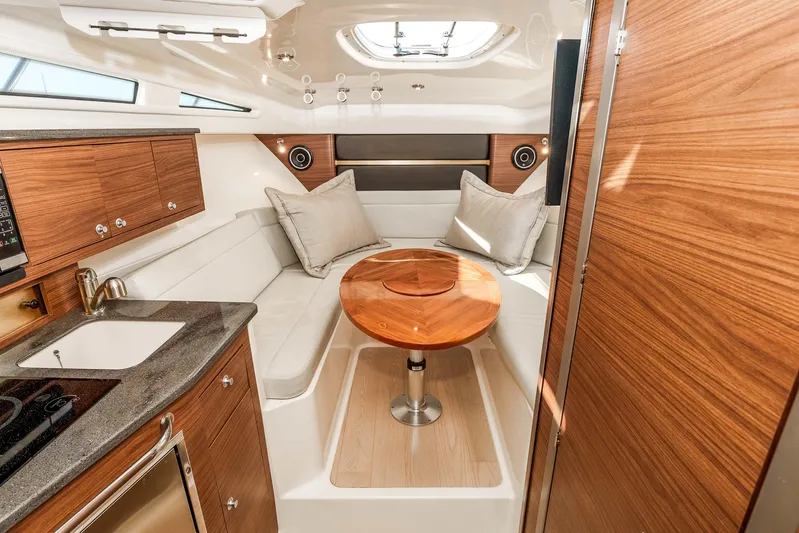 A Day In The Life Yacht Photos Pics Luxurious interior of 2021 Boston Whaler 325 Conquest boat with wood finishes and seating area.
