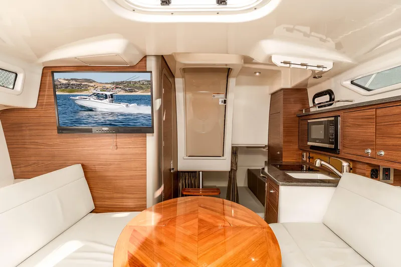 A Day In The Life Yacht Photos Pics Interior of 2021 Boston Whaler 325 Conquest with TV, kitchenette, and seating area.