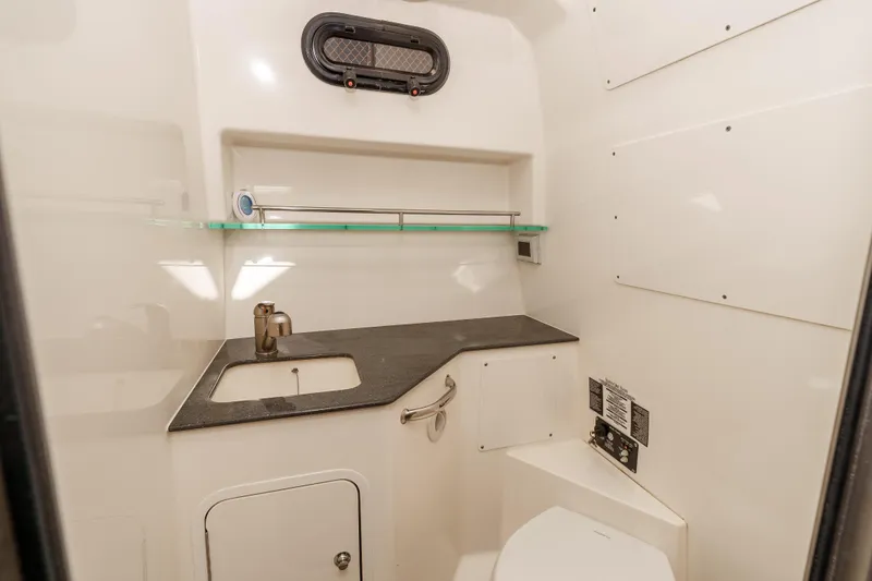 A Day In The Life Yacht Photos Pics 2021 Boston Whaler 325 Conquest bathroom with sink, toilet, and storage.
