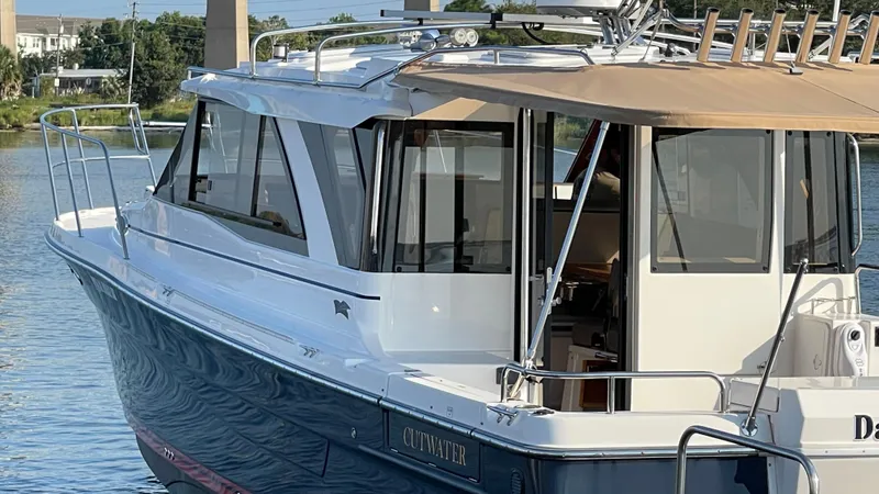  Yacht Photos Pics 2022 Cutwater C-32 Sedan boat docked on calm water, featuring sleek design and spacious cabin.
