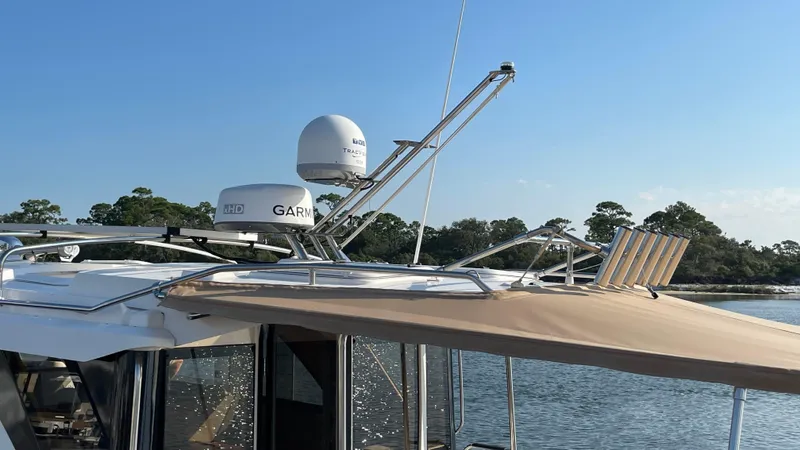  Yacht Photos Pics 2022 Cutwater C-32 Sedan with Garmin radar, docked by a scenic shoreline.