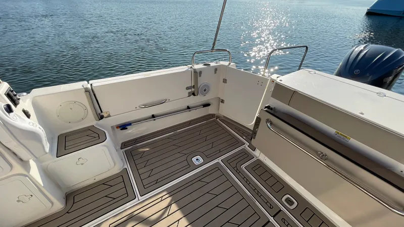  Yacht Photos Pics 2022 Cutwater C-32 Sedan boat deck with wood finish, overlooking calm water.